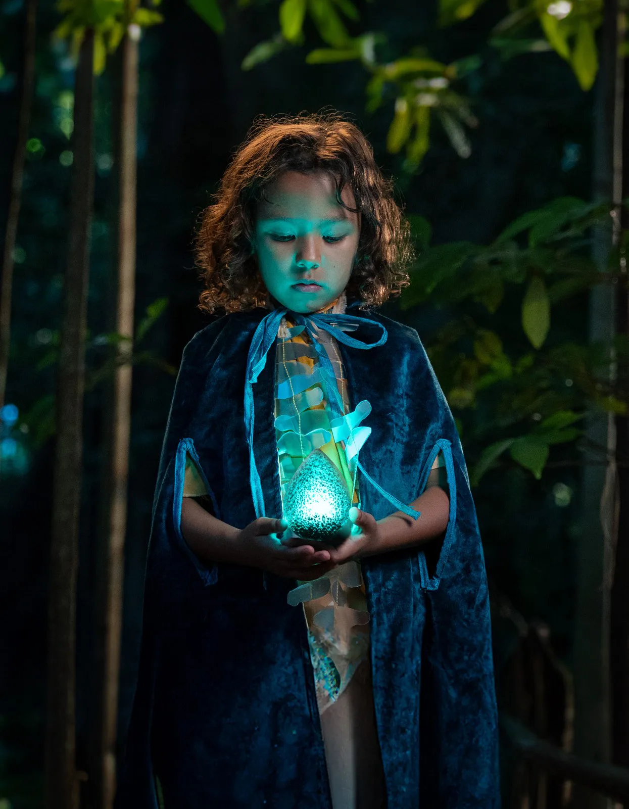 Miriki — a child in costume holding a glowing prop